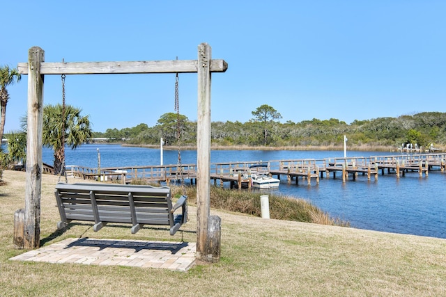 view of dock featuring a lawn and a water view