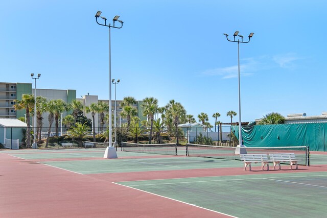 view of tennis court with community basketball court and fence