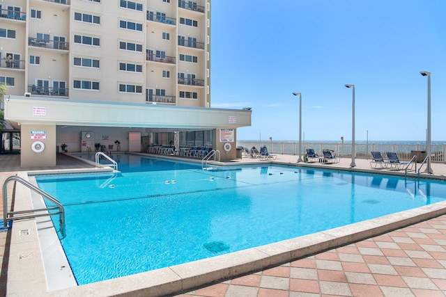 view of swimming pool with a patio area and fence