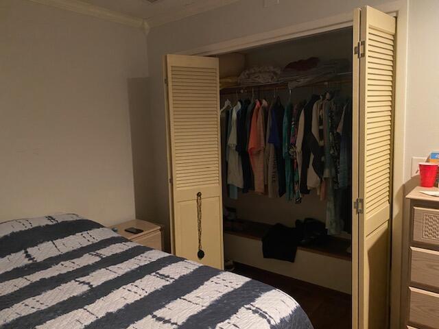 bedroom with a closet and ornamental molding