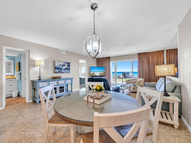 dining space featuring a chandelier, visible vents, and baseboards