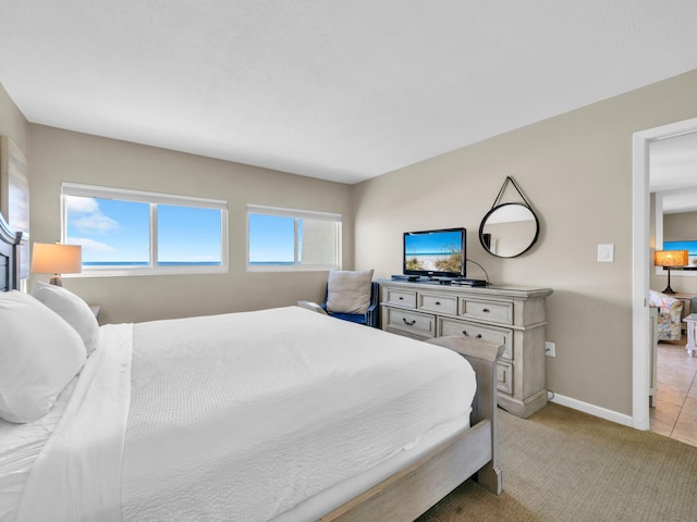 bedroom with baseboards and light colored carpet