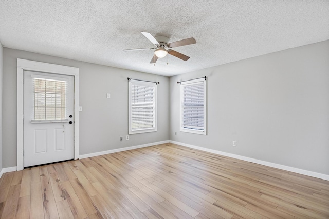 foyer entrance featuring light wood finished floors, ceiling fan, a textured ceiling, and baseboards