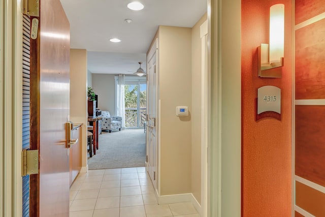 corridor featuring light tile patterned floors, baseboards, light carpet, and recessed lighting