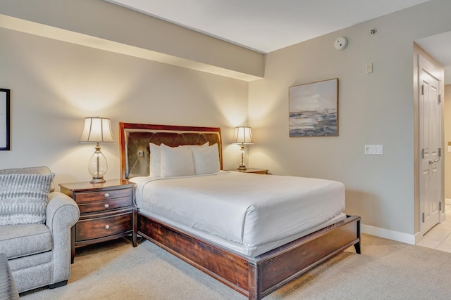 bedroom featuring light carpet and baseboards