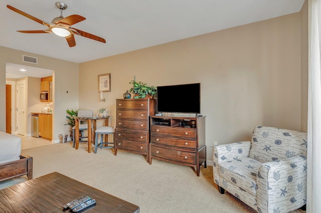 living room with visible vents, light colored carpet, baseboards, and a ceiling fan