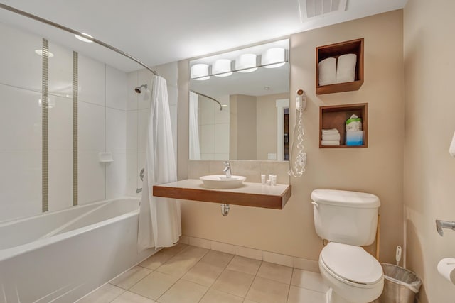 bathroom with tile patterned flooring, visible vents, toilet, shower / tub combo with curtain, and a sink