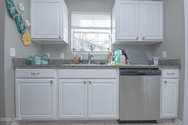 kitchen featuring dishwasher, white cabinetry, and a sink