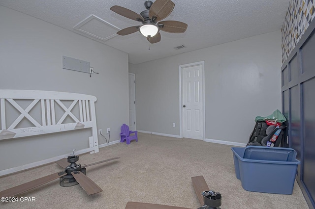 interior space featuring visible vents, a textured ceiling, carpet, baseboards, and attic access