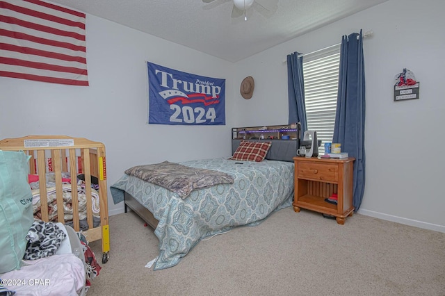 bedroom with ceiling fan, baseboards, carpet floors, and a textured ceiling