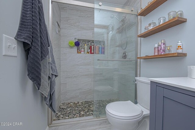 bathroom featuring vanity, toilet, marble finish floor, and a marble finish shower