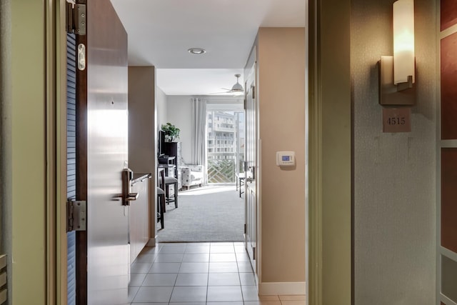 corridor featuring light tile patterned floors and light carpet