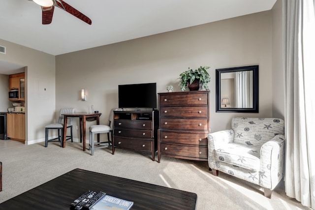 carpeted living area with baseboards, visible vents, and ceiling fan