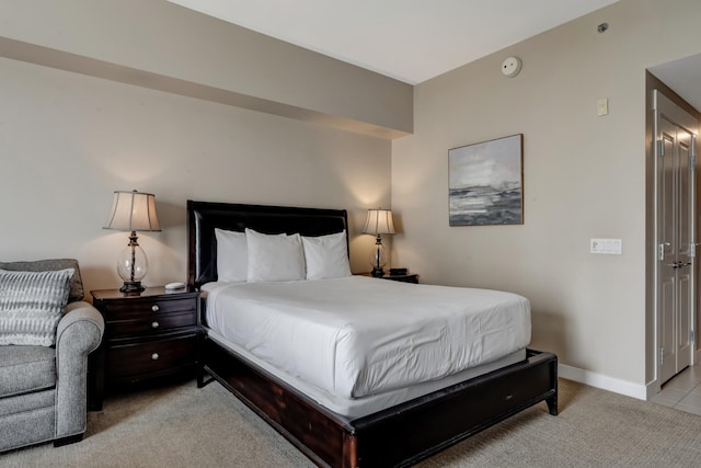 bedroom with light carpet and baseboards