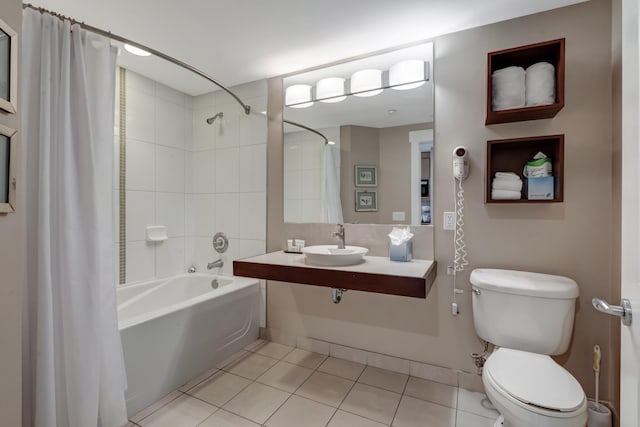 bathroom with tile patterned flooring, shower / bath combination with curtain, toilet, and a sink