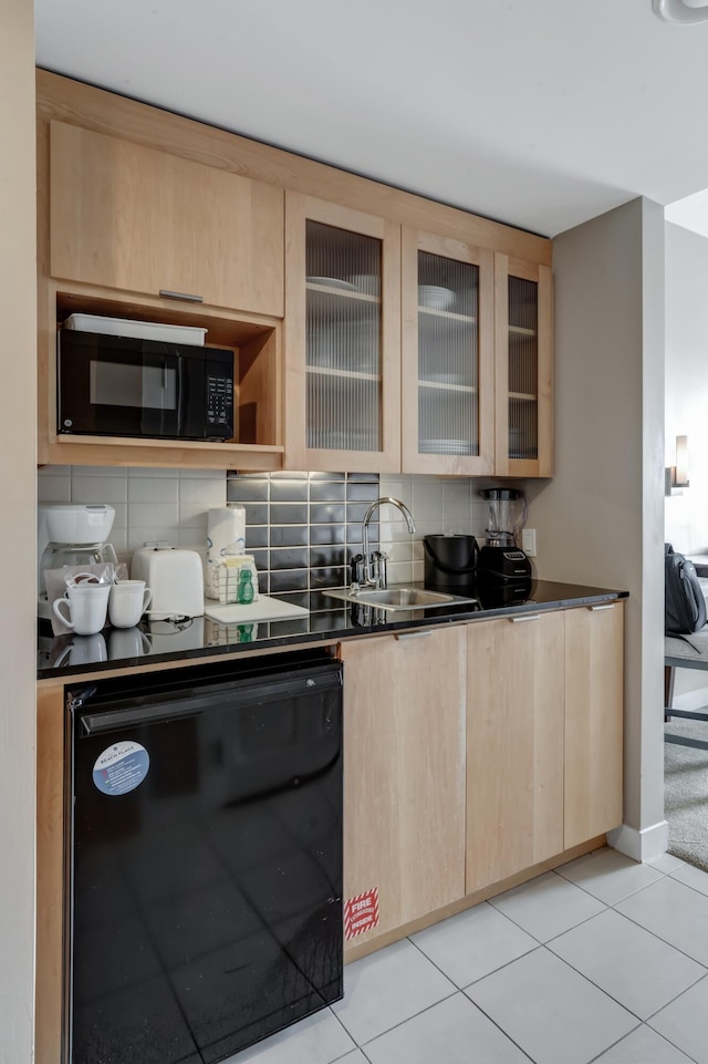 kitchen featuring dark countertops, black appliances, and light brown cabinets