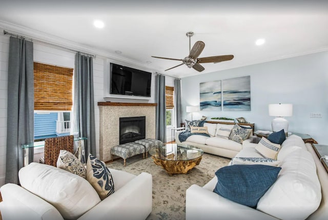 living area with recessed lighting, a fireplace, ornamental molding, and a ceiling fan