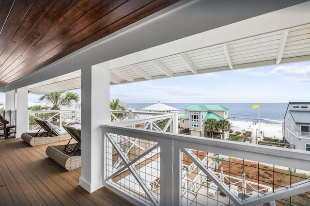 wooden deck with a pergola, a view of the beach, and a water view