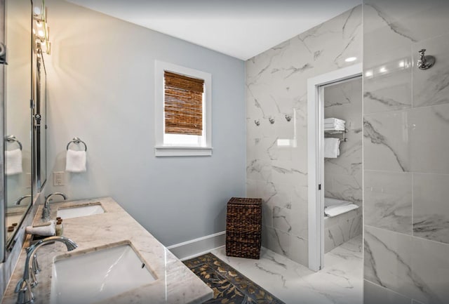 full bath featuring a sink, marble finish floor, double vanity, and a washtub