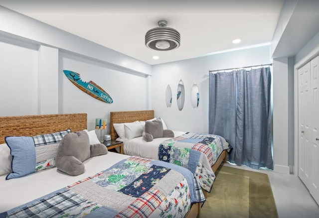 bedroom with a closet, recessed lighting, and finished concrete flooring