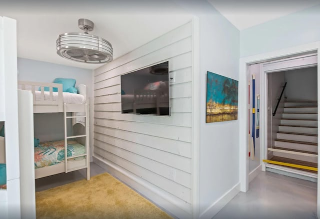 unfurnished bedroom featuring finished concrete flooring and baseboards