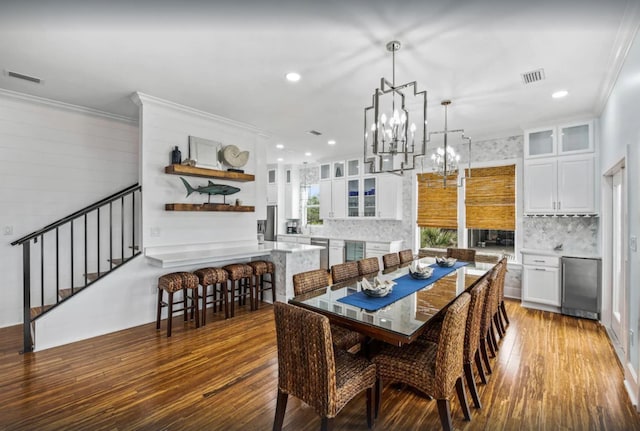 dining area featuring stairway, wood finished floors, visible vents, and ornamental molding