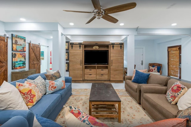 living room with a ceiling fan, a barn door, and recessed lighting