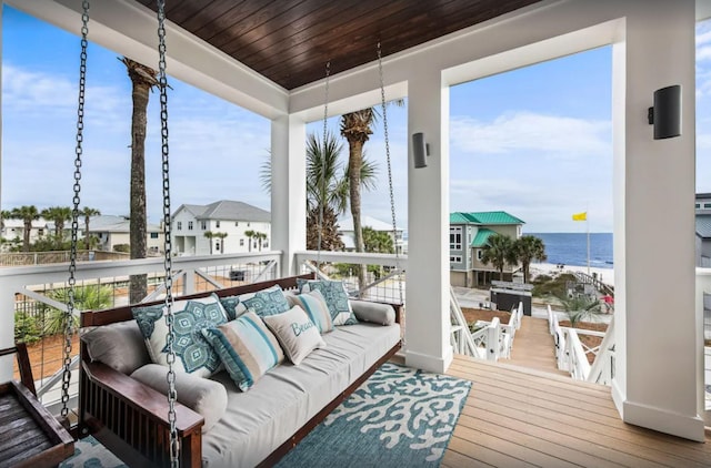 sunroom / solarium featuring a water view and wood ceiling