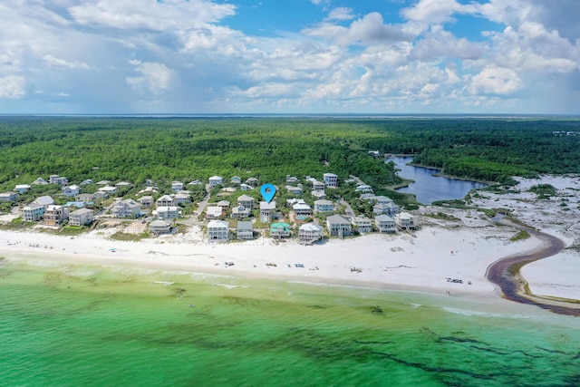 aerial view featuring a forest view, a beach view, and a water view