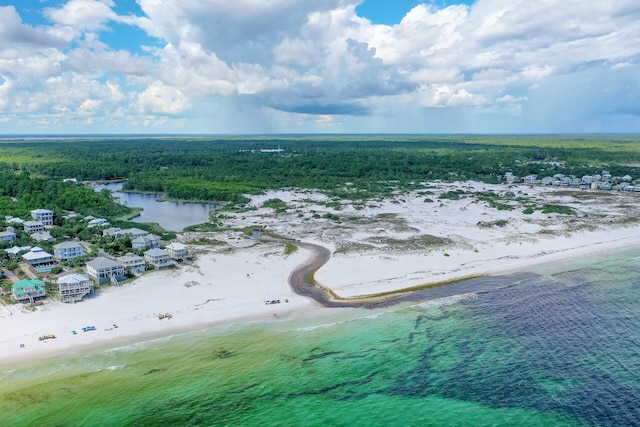 bird's eye view featuring a wooded view, a view of the beach, and a water view