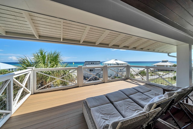 wooden terrace featuring a view of the beach and a water view