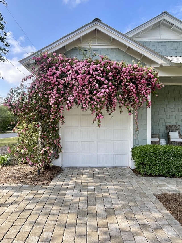 exterior space featuring decorative driveway and a garage