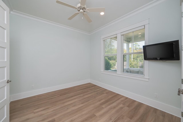 empty room featuring ceiling fan, light wood-style flooring, baseboards, and ornamental molding