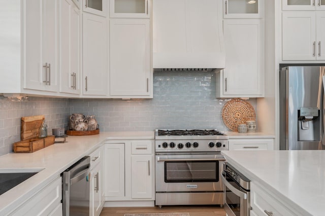 kitchen featuring stainless steel appliances, white cabinetry, and light countertops