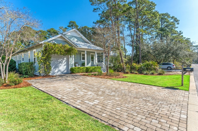 view of front of property featuring decorative driveway, a garage, a porch, and a front lawn