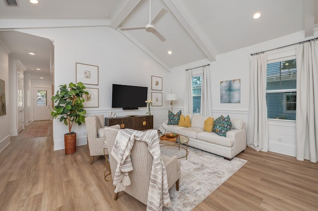 living room with visible vents, beam ceiling, a ceiling fan, light wood-style floors, and wainscoting