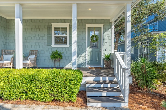 view of exterior entry featuring covered porch