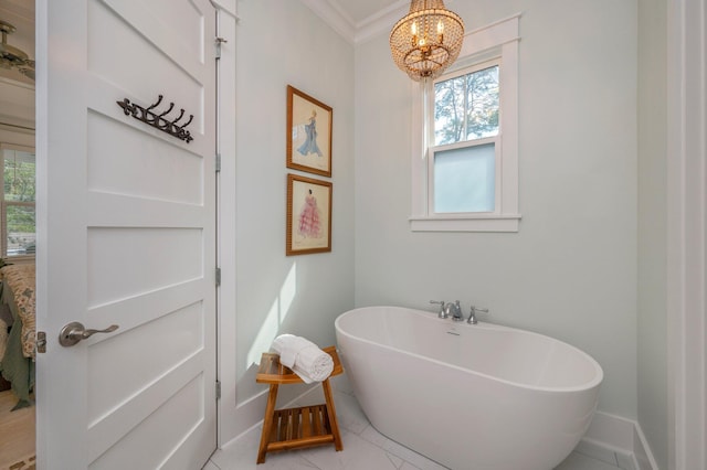 bathroom featuring ornamental molding, baseboards, a chandelier, and a freestanding bath