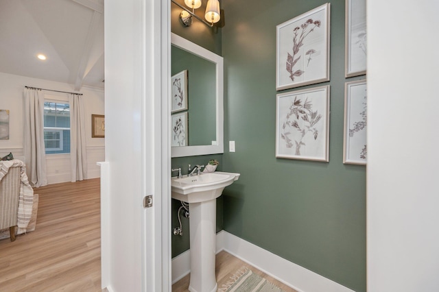 bathroom with a sink, baseboards, and wood finished floors