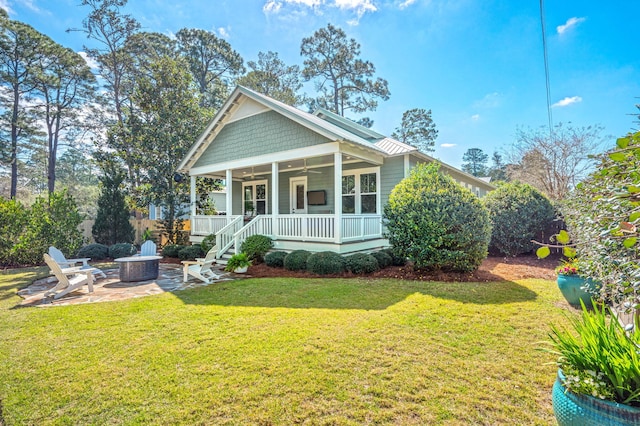 view of front facade featuring a ceiling fan, a front lawn, a patio, a fire pit, and a sunroom