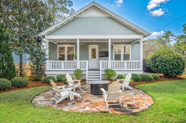 view of front of property featuring a patio, fence, a porch, ceiling fan, and a front lawn