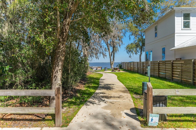 view of community featuring a yard and fence