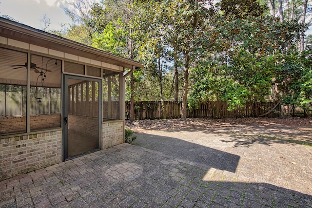 view of patio / terrace featuring fence and a sunroom