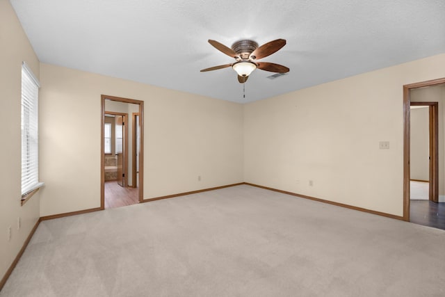 empty room featuring visible vents, baseboards, ceiling fan, and carpet floors