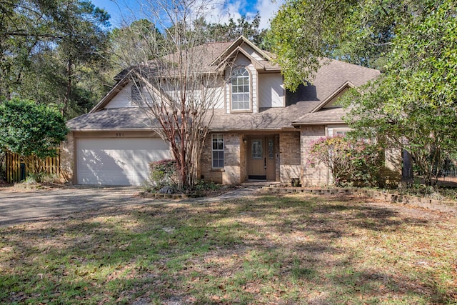 traditional-style house featuring a front lawn, aphalt driveway, fence, a shingled roof, and a garage