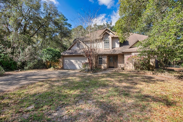 traditional home featuring aphalt driveway, a garage, roof with shingles, and a front lawn