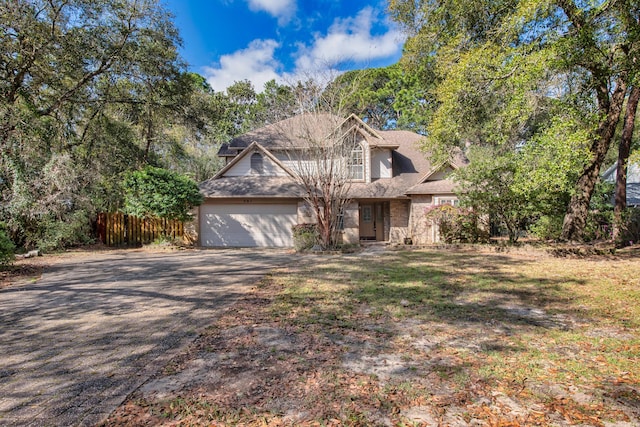 view of front of home featuring an attached garage, fence, and driveway