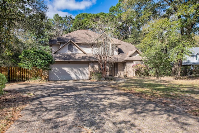 view of front of property featuring an attached garage, decorative driveway, roof with shingles, and fence