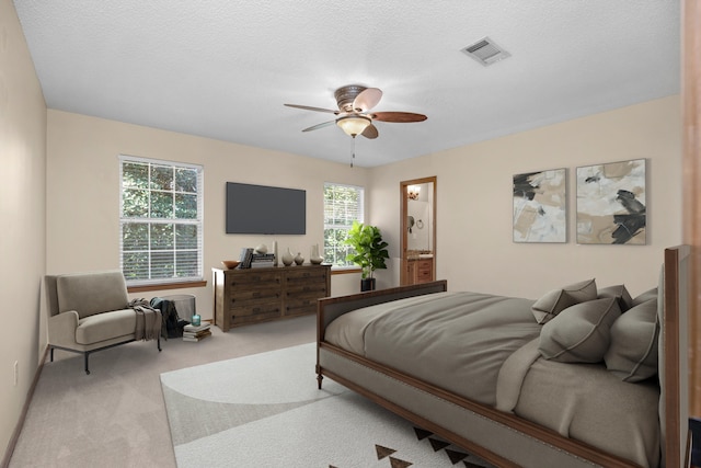 bedroom with ceiling fan, visible vents, carpet floors, and a textured ceiling