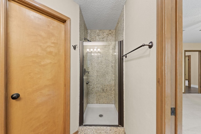 bathroom featuring a shower stall and a textured ceiling